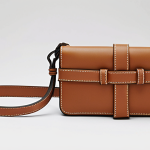Gate Wallet**

Prompt: "Close-up of a Loewe Gate wallet, showcasing its soft leather texture and distinctive knotted closure. Emphasize the craftsmanship and subtle elegance. Soft, diffused lighting. Italian style, high-fashion."

**