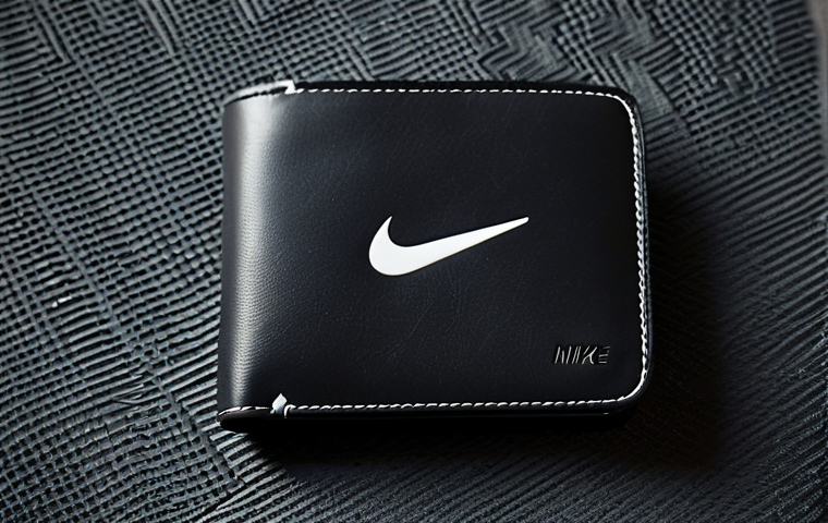 나이키와 아디다스 스포츠 지갑 비교 - Nike Minimalist Wallet**

"A close-up shot of a black Nike sporty wallet, fully closed, lying on a t...